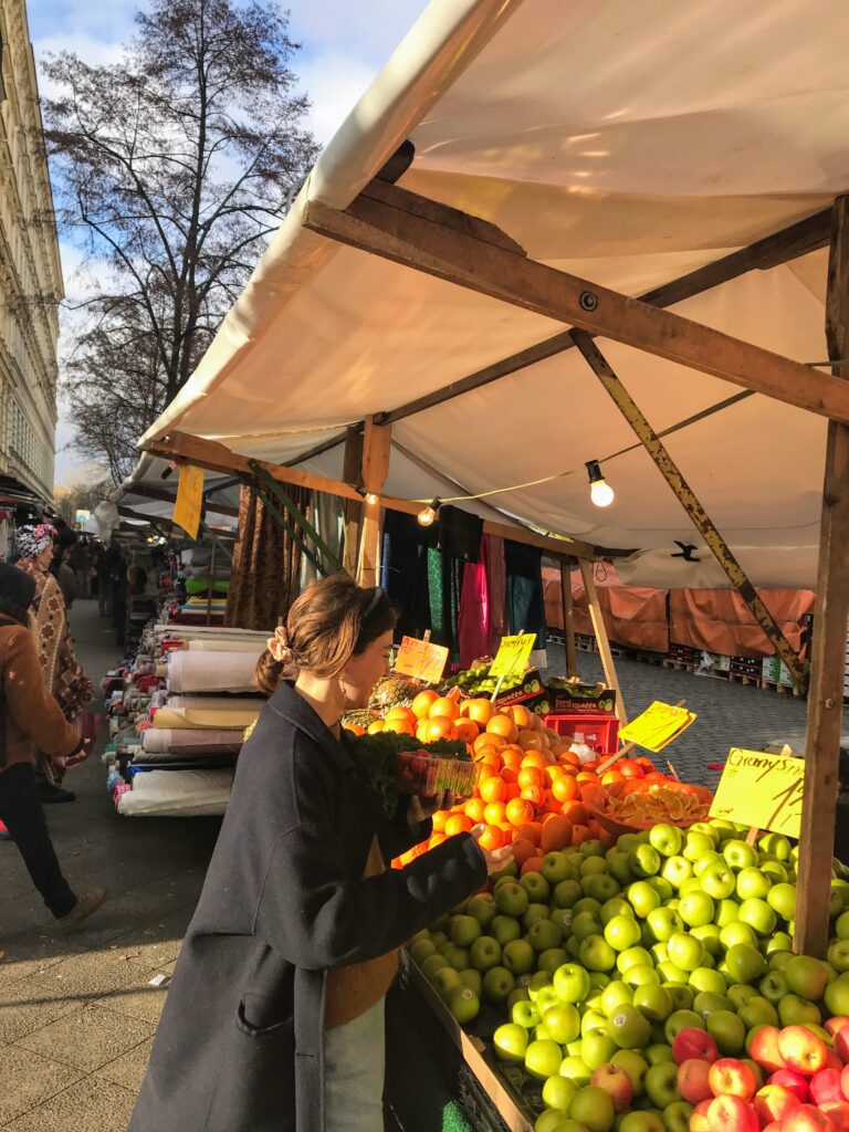 Woman standing in front of fruit stall at market