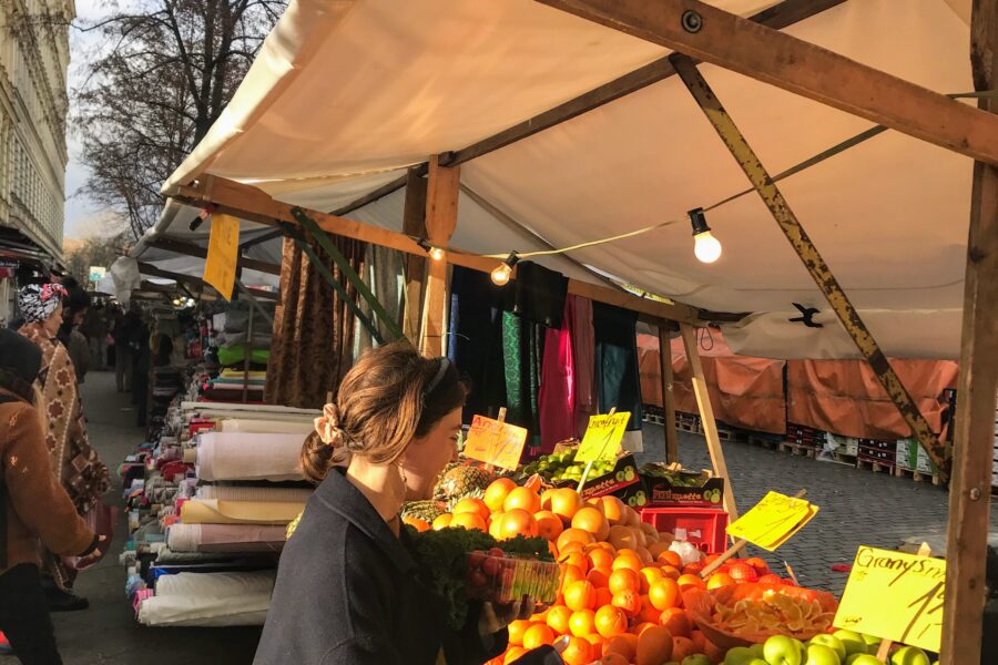 Woman standing in front of fruit stall at market