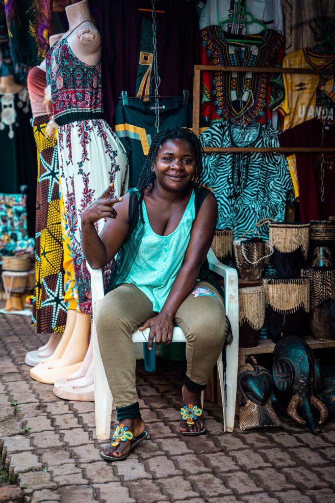 best markets in kampala, uganda Woman sitting on a chair in front of a store