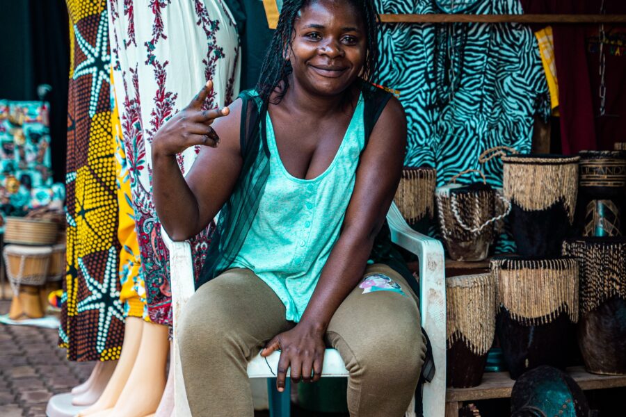 best markets in kampala, uganda Woman sitting on a chair in front of a store