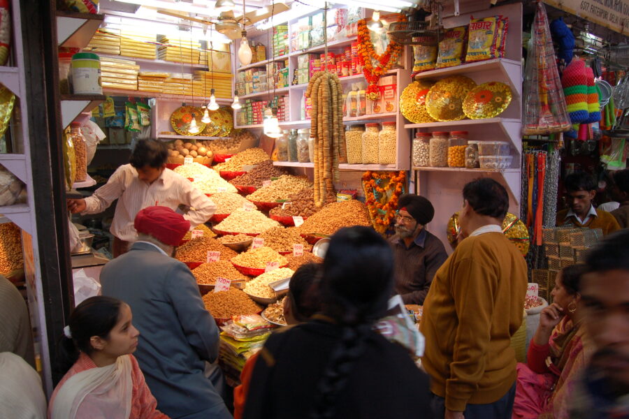 People shopping at stall selling nuts at a market in India