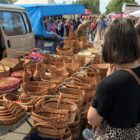 Woman standing in front on wicker baskets at a market