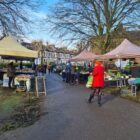 people walking between market stalls in daylight