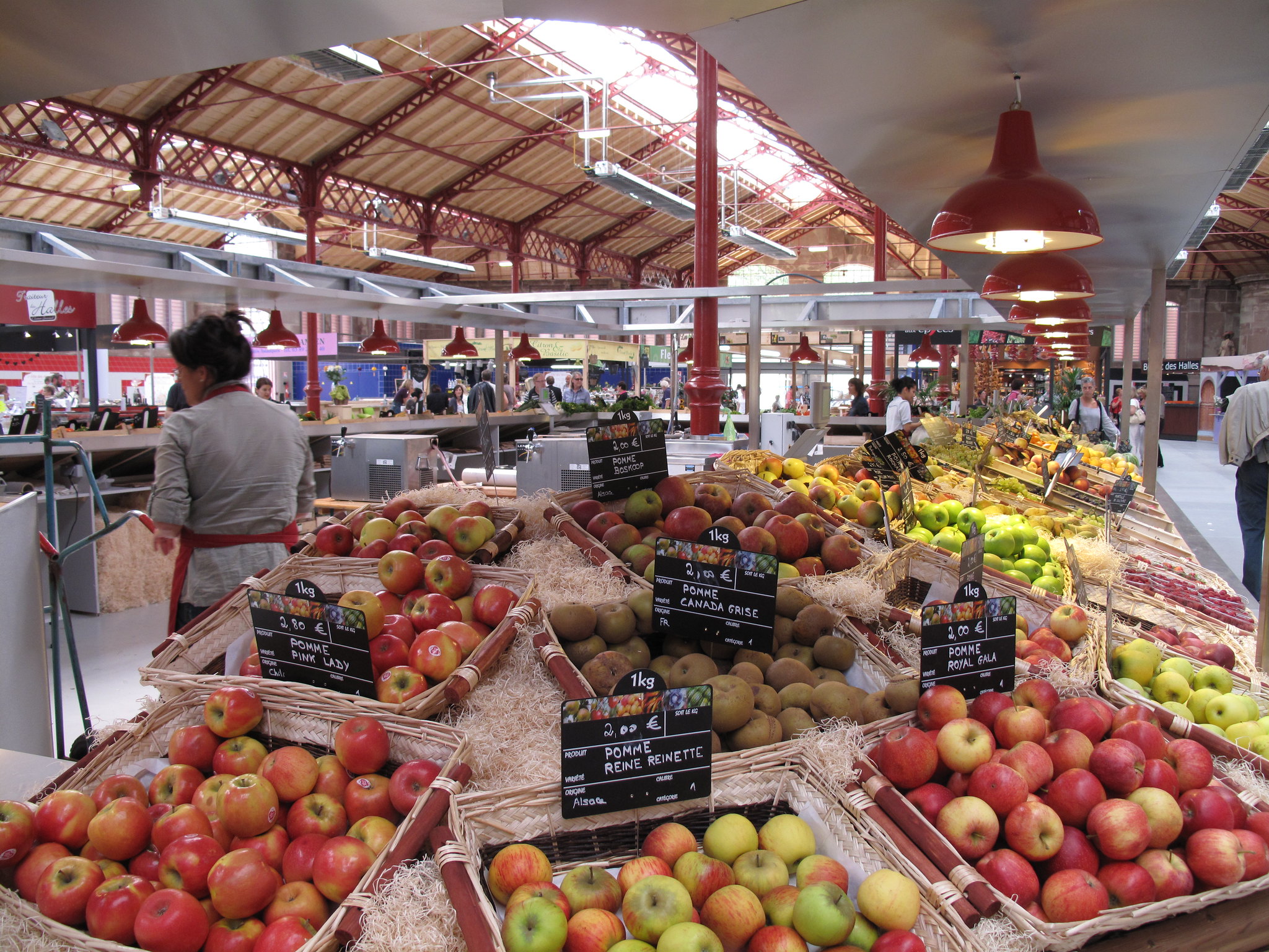 apples and other fruit on a market stand in a covered market