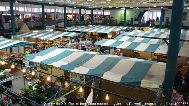 Shrewsbury Market Hall white and green striped tents from above inside an indoor market hall