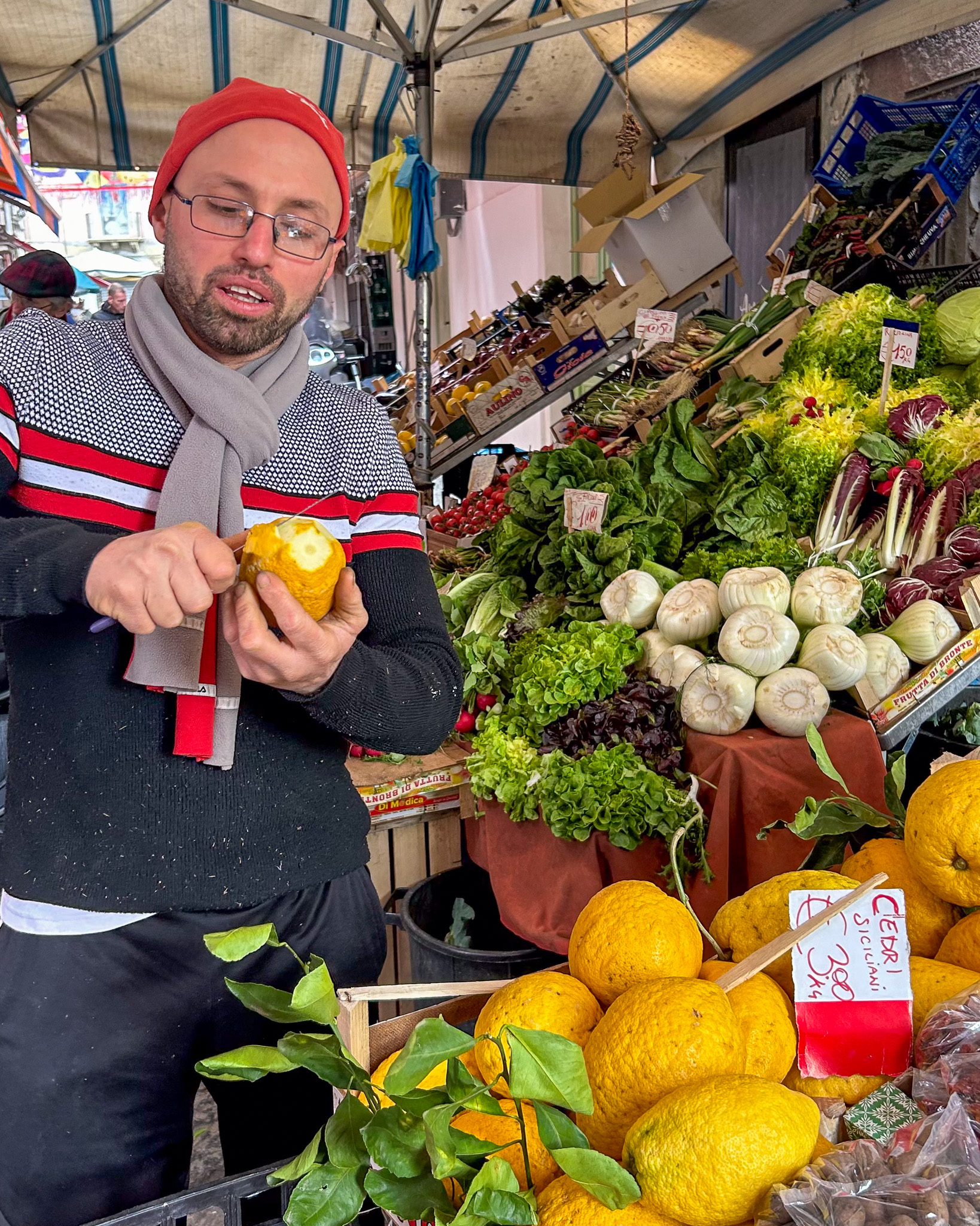 Market vendor peeling a citron at one of the markets in Catania